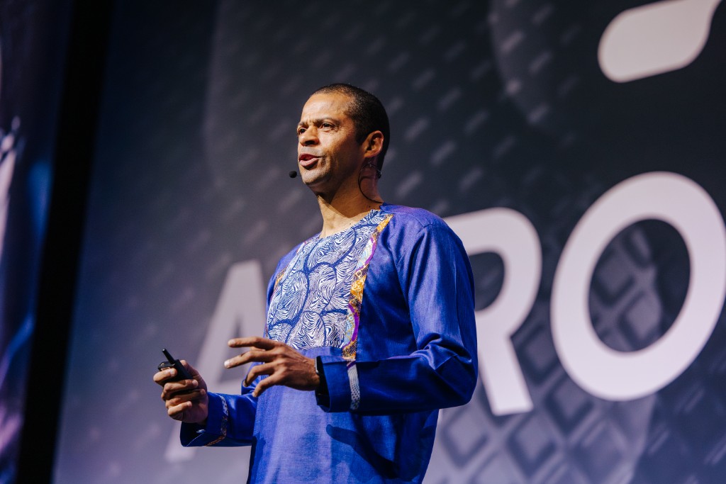Speaker wearing a headset microphone presenting on stage at AfroTech